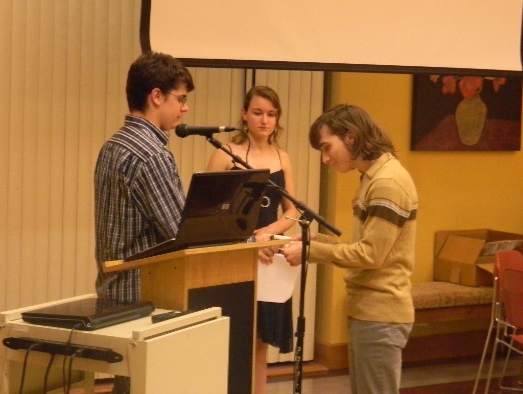 Justin Gelemore hands Ryan Wolf a certificate and a pin after inducting him into the Sigma Tau Delta chapter on campus. Sigma Tau Delta is the international English honors society. 