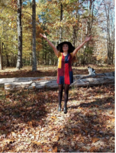 Emily Hutson showing off that 70's dress as she tosses a handful of leaves in the air like she just don't care